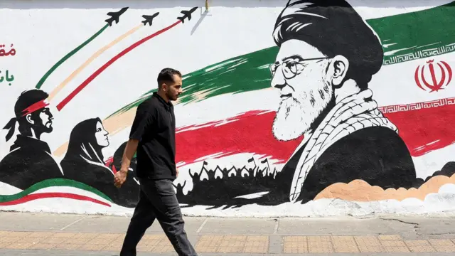 رجل يمر أمام جدارية تصوّر المرشد الأعلى الإيراني الراحل آية الله علي خامنئي في طهران بتاريخ 24 يوليو/تموز 2026.
