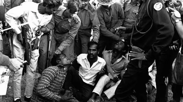 মুক্তিবাহিনীর সশস্ত্র যোদ্ধারা রাজাকার সন্দেহে কয়েকজনকে ঘিরে ধরেছে