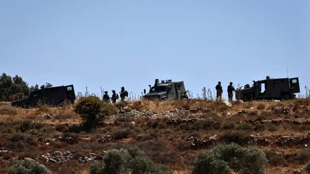 جنود من الجيش الإسرائيلي يتخذون موقعاً على تلة قرب قرية سنجل، في الضفة الغربية المحتلة، في 18 يوليو/تموز 2025، بعد مقتل فلسطينيين يحملان الجنسية المزدوجة في اشتباكات مع مستوطنين إسرائيليين. 