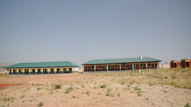 Deux blocs de salles de classe rénovés, l'un peint en crème et vert et l'autre en vin et vert, à Kuriga.