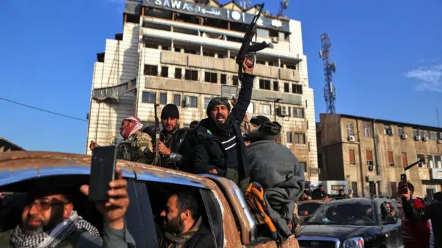 Para pejuang pemberontak Suriah merayakan kemenangan di Homs pada 8 Desember 2024