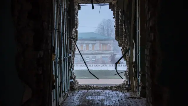 через дыру в стене видно платформу и здание