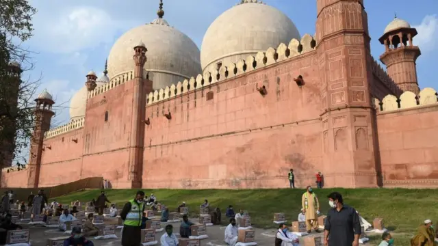 Dad gaajeysan oo ramadaanta ka hor cunto loogu qeybiyay bannaanka masaajidka Badshahi ee Lahor, Pakistan.