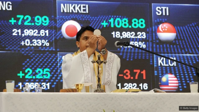 Un prêtre catholique romain officie la messe le premier jour de négociation à la Bourse des Philippines à Manille