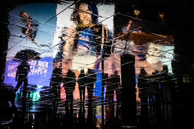 Rainy reflections of adverts.