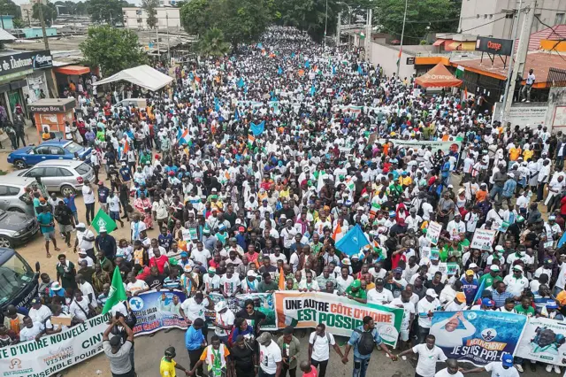 Cette vue aérienne montre des partisans de différents partis d'opposition lors d'une marche appelant à une élection inclusive dans le quartier de Yopougon à Abidjan le 9 août 2025, avant l'élection présidentielle du 25 octobre 2025.