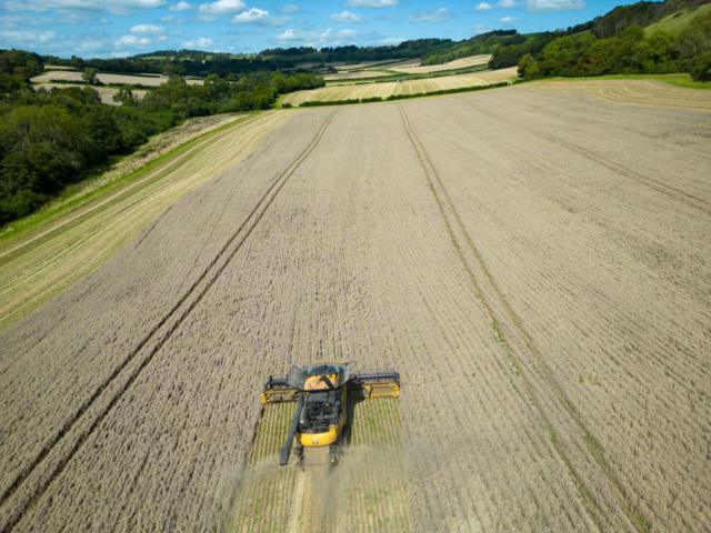 Trator passa por um campo cultivado