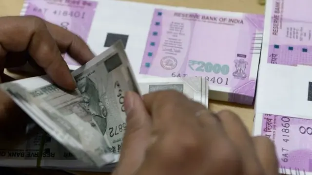 પૈસા ગણતી એક વ્યક્તિ