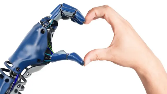 Mano robótica y mano humano haciendo la forma de corazón