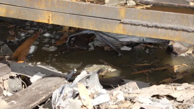 د ناستې د سالون پر غولي د بمب جوړه کړې کنده لا هم لیدل کېږي. د باران اوبه په کې راټولې شوې.