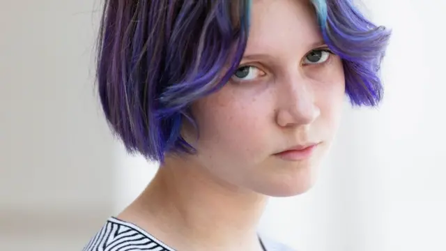 Adolescente com cabelo roxo