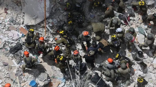Equipes de resgate procuram por pessoas desaparecidas sob os escombros