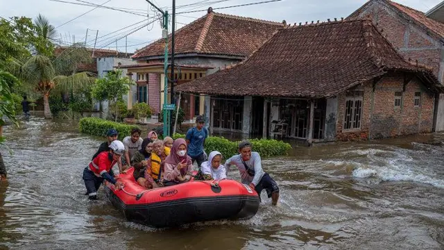 Relawan menggunakan perahu karet mengevakuasi warga yang rumahnya terendam banjir akibat jebolnya tanggul Sungai Jratun-Wulan, di Desa Undaan Kidul, Kecamatan Karanganyar, Kabupaten Demak, Jawa Tengah, Kamis (8/2/2024).