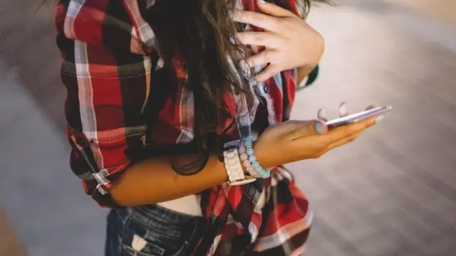 فتاة تتصفح هاتفها المحمول