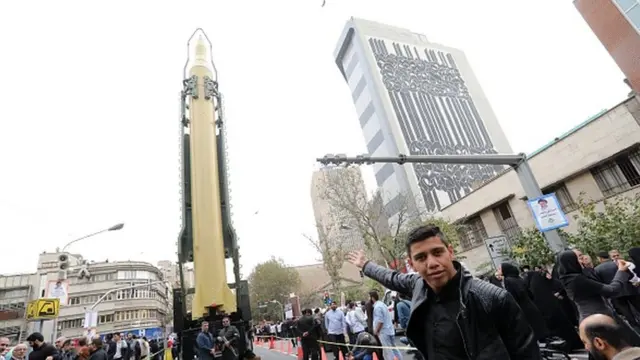ranians gather next to a replica of a Ghadr medium-range ballistic missile during a demonstration outside the former US embassy in the Iranian capital Tehran