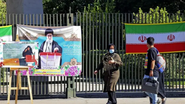 مردم از کنار تبلیغات انتخاباتی عبور می‌کنند