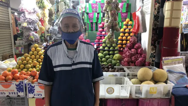 Pedagang pasar memakai face shield