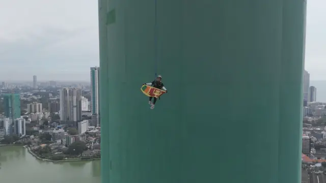 නෙලුම් කුලුනද කඹයක ආධාරයෙන් පහළට බසින