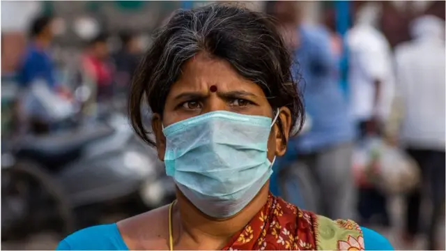 માસ્ક પહેરેલા મહિલાની તસવીર