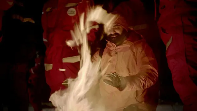 Researchers gathered around camp fire