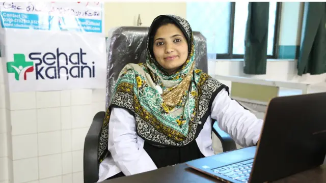 Fatima sitting at a laptop in a health clinic