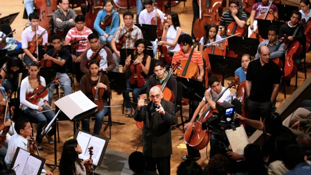 Abreu rodeado de un orquesta de jóvenes.