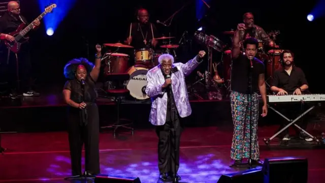 Em cima do palco, Tony canta e dança 