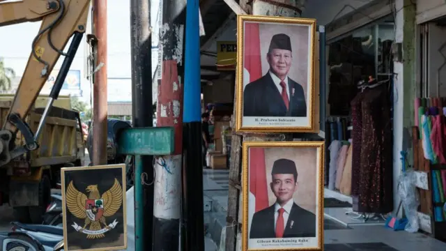 Potret Presiden Prabowo Subianto (atas) dan Wakil Presiden Gibran Rakabuming Raka dipajang di tiang untuk berjualan di depan toko PKL di Banda Aceh, Indonesia, pada 27 Desember 2024.