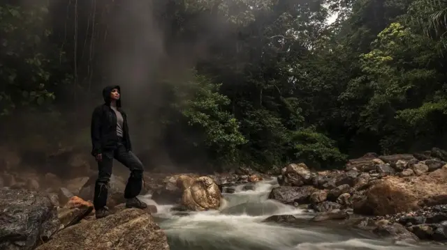 Farwiza Farhan berdiri di sungai kawasan Leuser.