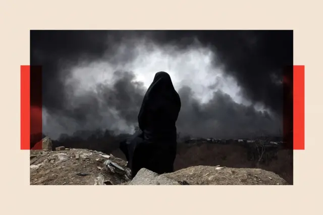 A view from the back of a woman wearing a chador, who surveys the scene as black smoke billows across the landscape
