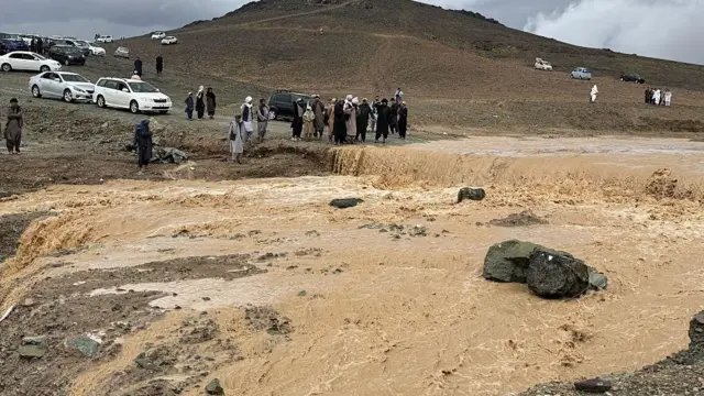 سرازیر شدن سیلاب که باعث شده آنطرف تعداد از افراد و موترها متوقف بمانند.