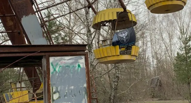 Прапор на прип'ятському колесі огляду з написом "Нам силу дають вогонь і лють" (лютий 2024 року)