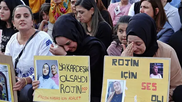 Rojin Kabaiş'in arkadaşları protestoda onun fotoğraflarını tutuyor, ikisi de ağlıyor
