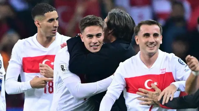 Kenan Yıldız takım arkadaşlarıyla kucaklaşarak seviniyor, Montella'ya da sarılıyor