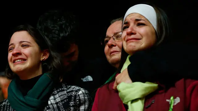 স্যান্ডি হুকে নিহতদের স্মরণ সভায় ক'জন শোকার্ত মানুষ।