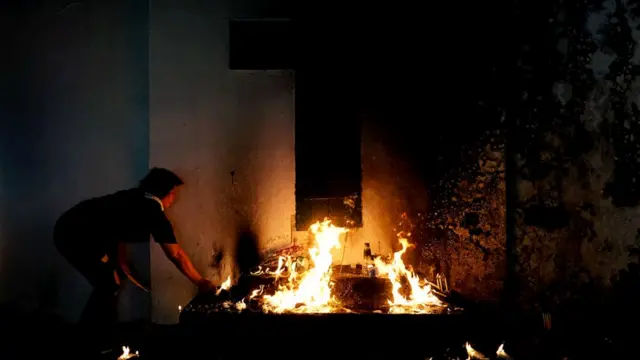 Женщина зажигает свечи на кладбище в Маниле (Филиппины) во время празднования Дня всех святых