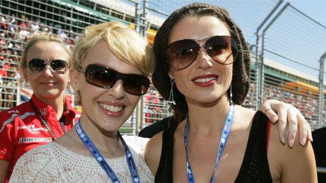Singers Kylie Minogue (L) and sister Dannii Minogue pose on the grid at the Australian Formula One Grand Prix at the Albert Park Circuit on 18 March 2007 in Melbourne, Australia