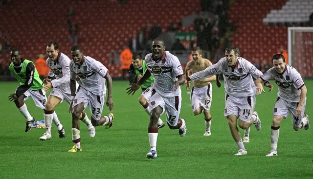Nathaniel Wedderburn del Northampton Town y sus compañeros de equipo celebran después de ganar una tanda de penaltis durante el partido de la tercera ronda de la Copa Carling entre Liverpool y Northampton Town en Anfield.