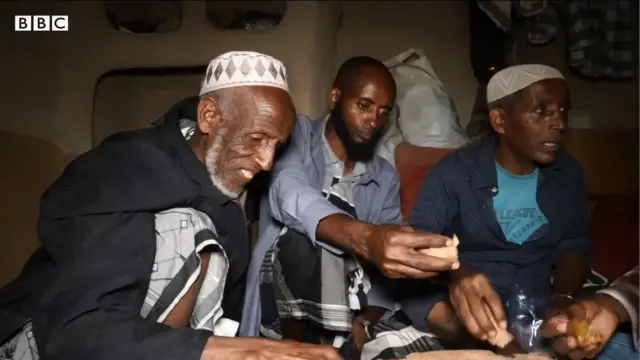 ภาคแคปหน้าจอ อิหม่าม (ซ้าย) กำลังกินข้าวกับผู้ชายอีก 2 คน