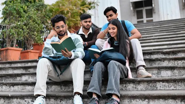 कॉलेज कैम्पस में बैठे हुए छात्र और छात्रा