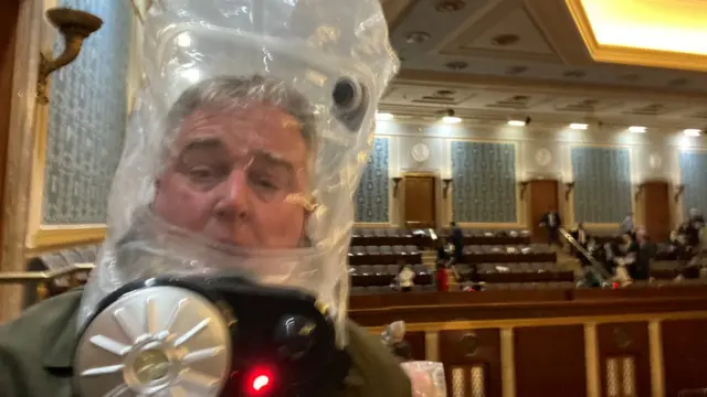 El miembro de la Cámara de Representantes David Trone usando una máscara anti gases lacrimógenos dentro del Capitolio.