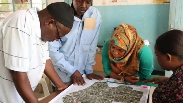 Un groupe de Tanzaniens regardant la carte Open Source.