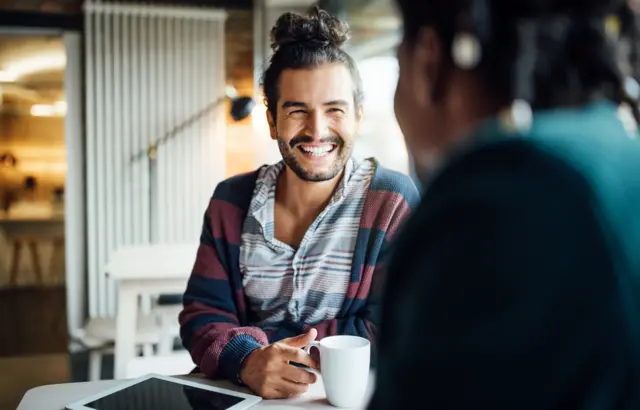 Homem tomando café com colega7games baixar aplicativo appescritório