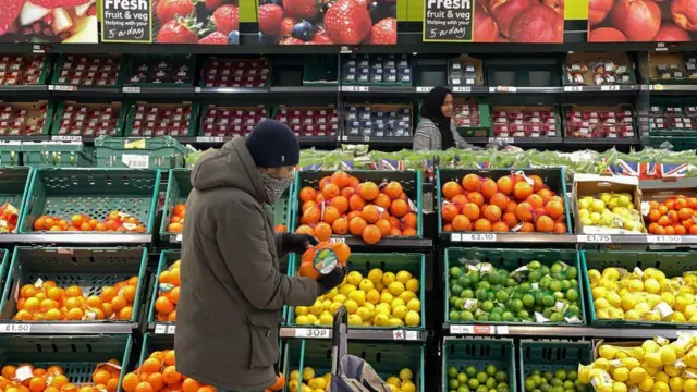 Une personne regardant les fruits et légumes dans un supermarché
