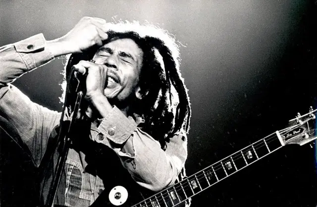 Foto preta e branca de Bob Marley durante uma apresentação