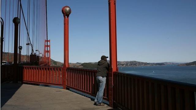 A man looks at the view from the Golden Gate Bridge