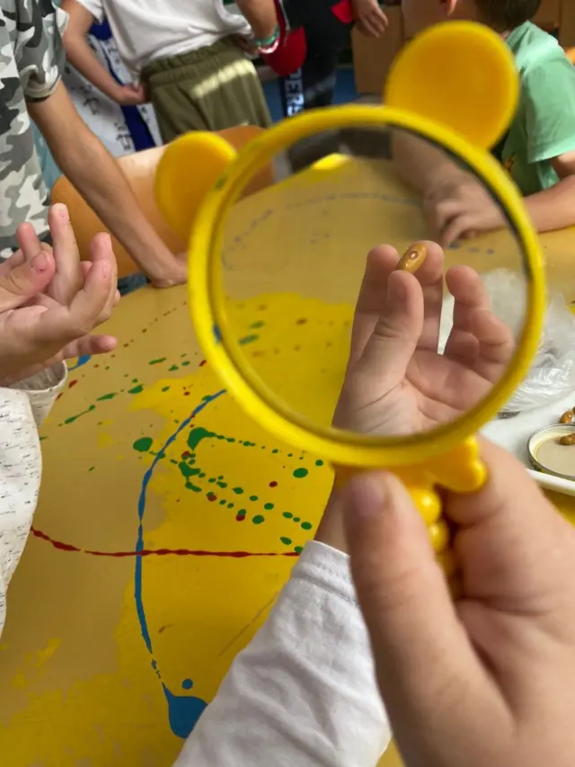 dete pod lupom posmatra zrno pasulja