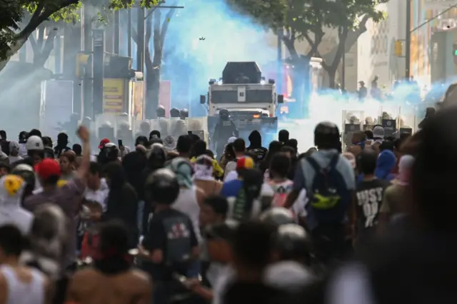 Manifesntantes frente a vehículos blindados