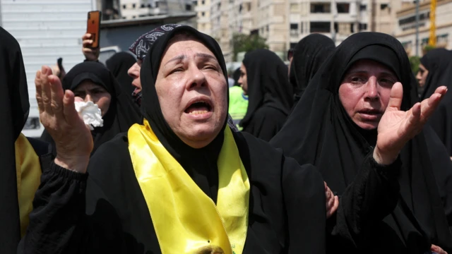 Uma mulherjogo de roleta que dá dinheirohijab preto e pano amarelo chorajogo de roleta que dá dinheirofuneral