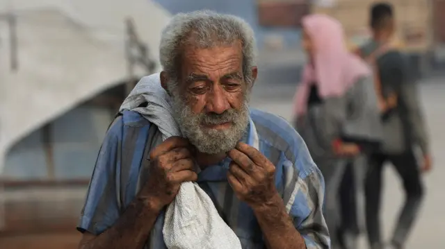 فلسطيني يحمل مساعدات في بيت لاهيا في شمال قطاع غزة، في 10 أغسطس/آب 2025
